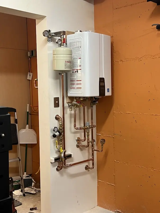Plumbing technician inspecting water heater connections in New Carrollton